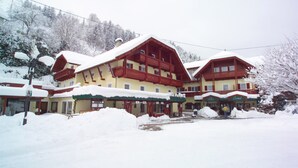 A multi-story hotel with a snow-covered roof and balconies. - Landhotel Kreinerhof - Self Check In 24h möglich (Lurnfeld)