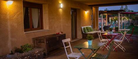 An outdoor patio area with a table and chairs, a fire pit, and a view of the surrounding landscape.