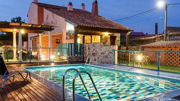 Una piscina al aire libre, sombrillas, tumbonas
