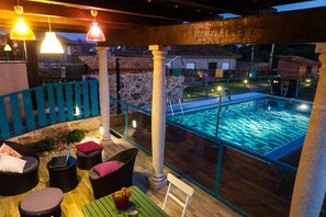 A rooftop pool area with seating and a view of the surrounding neighborhood.
