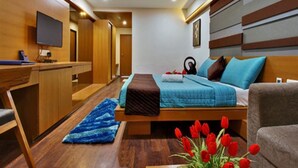 Ein modernes Hotelzimmer mit Bett, Schreibtisch und Fernseher.