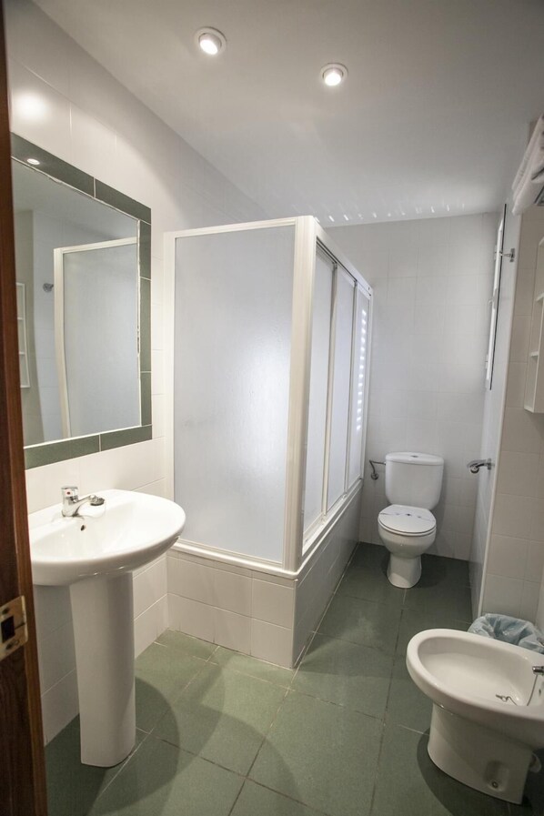 A bathroom with a pedestal sink, a toilet, a bidet, and a shower enclosure. - Hostal Venta del Sol (Baza)