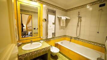 Un baño con un espejo grande, dos lavamanos, un bidé y una bañera.