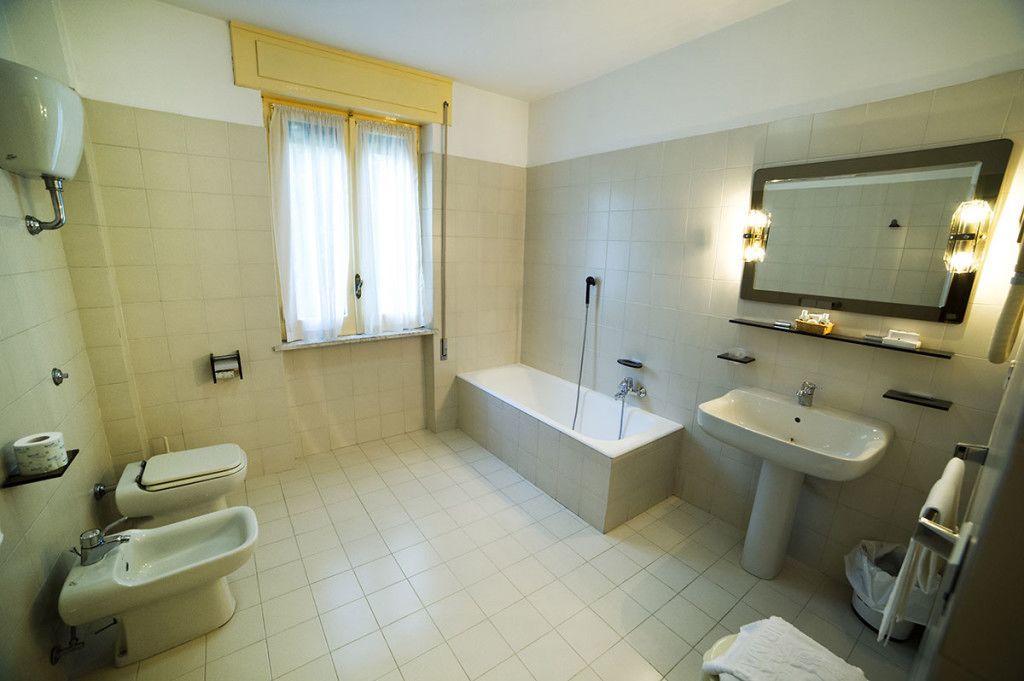 Un baño con inodoro, bidé, bañera y lavamanos.