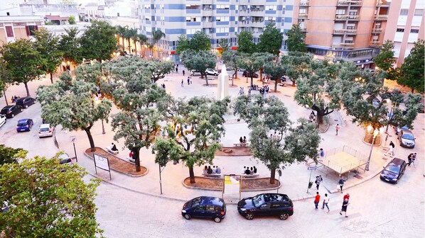 A circular plaza with trees, benches, and people.