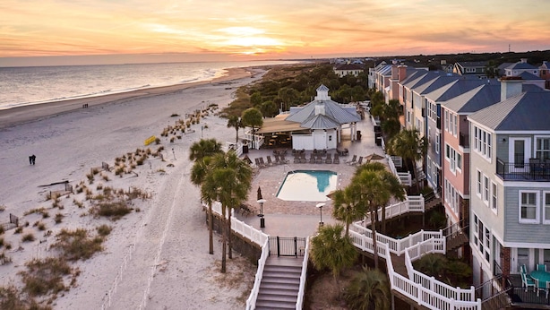 Een strandhotel met zwembad, toegang tot het strand en uitzicht op de zonsondergang.