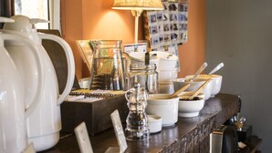 Un bar de cuisine équipé de divers ustensiles, notamment une bouilloire, une machine à café et des bocaux.