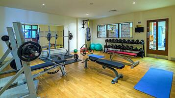 Een sportschool met gewichthefapparatuur, trainingsballen en dumbbells.