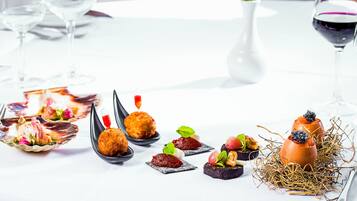 Una mesa dispuesta con diferentes aperitivos y una copa de vino tinto.
