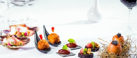 A table set with various appetizers and a glass of red wine.