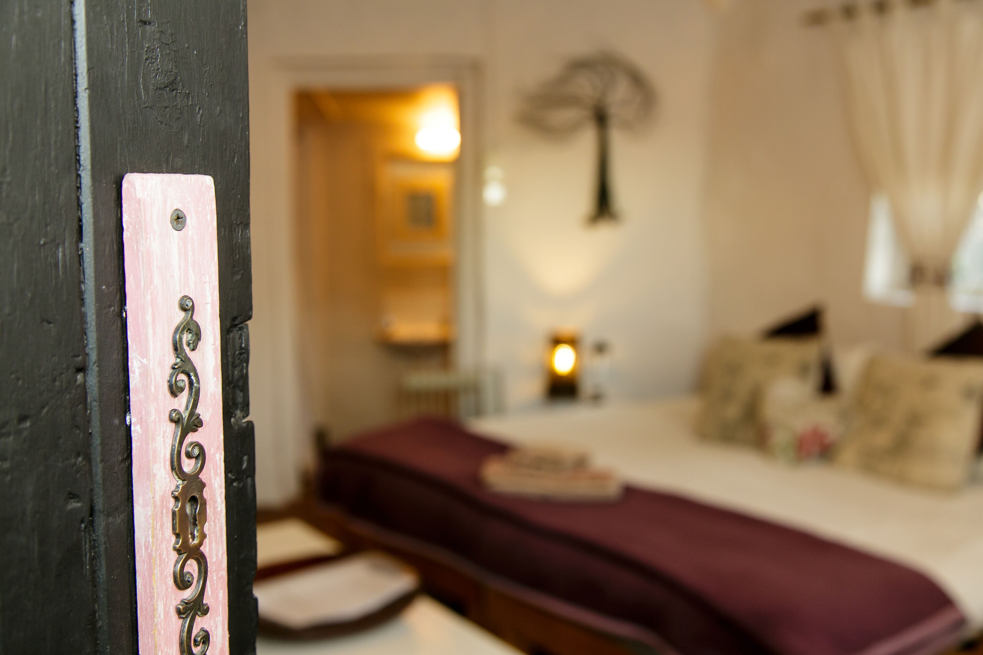 A bedroom with a bed, a bedside table, and a lamp.