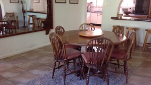 A dining room with a round table surrounded by wooden chairs, a large mirror on the wall, and a patterned rug on the floor. - Swaynekloof Farm (Bot River)