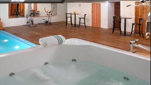 A spa area with a hot tub, a small pool, exercise equipment, and a dining area. - Hotel Monte Cervino (San Carlos de Bariloche)