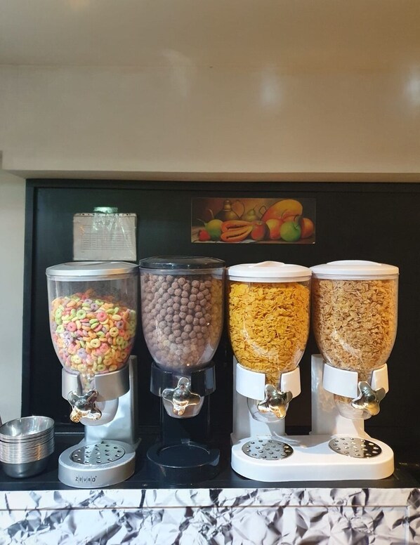 Four dispensers on a counter, each filled with different food items.