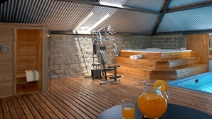 A wooden deck with a sauna, exercise equipment, and a hot tub. - Hotel Monte Cervino (San Carlos de Bariloche)