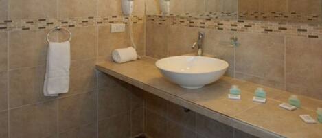 A bathroom with a large white sink, a towel rack, and a mirror.
