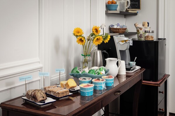 Une table de buffet proposant divers plats et une machine à café.