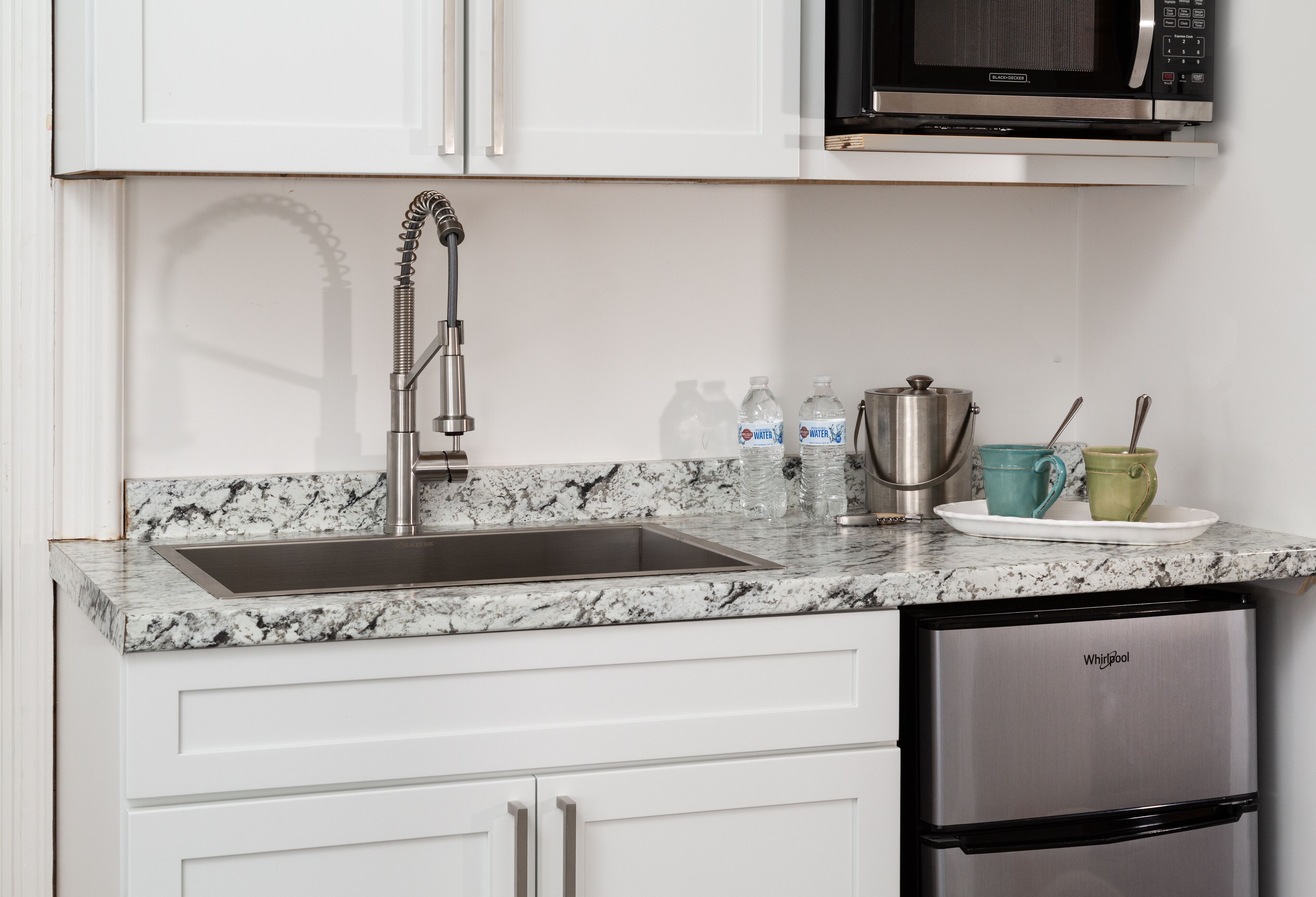 A kitchen with a stainless steel sink, a microwave, and a built-in dishwasher.