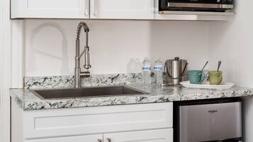 A kitchen with a stainless steel sink, a microwave, and a built-in dishwasher.