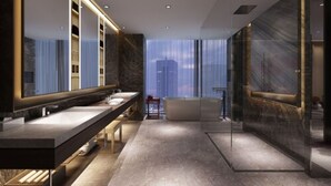 Un baño moderno con tocador de doble lavabo, un espejo grande y una zona de ducha con mampara de vidrio.