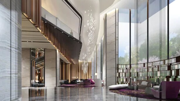 Un hall amplio con techo alto, una zona de estar central y grandes ventanales con vistas al exterior.