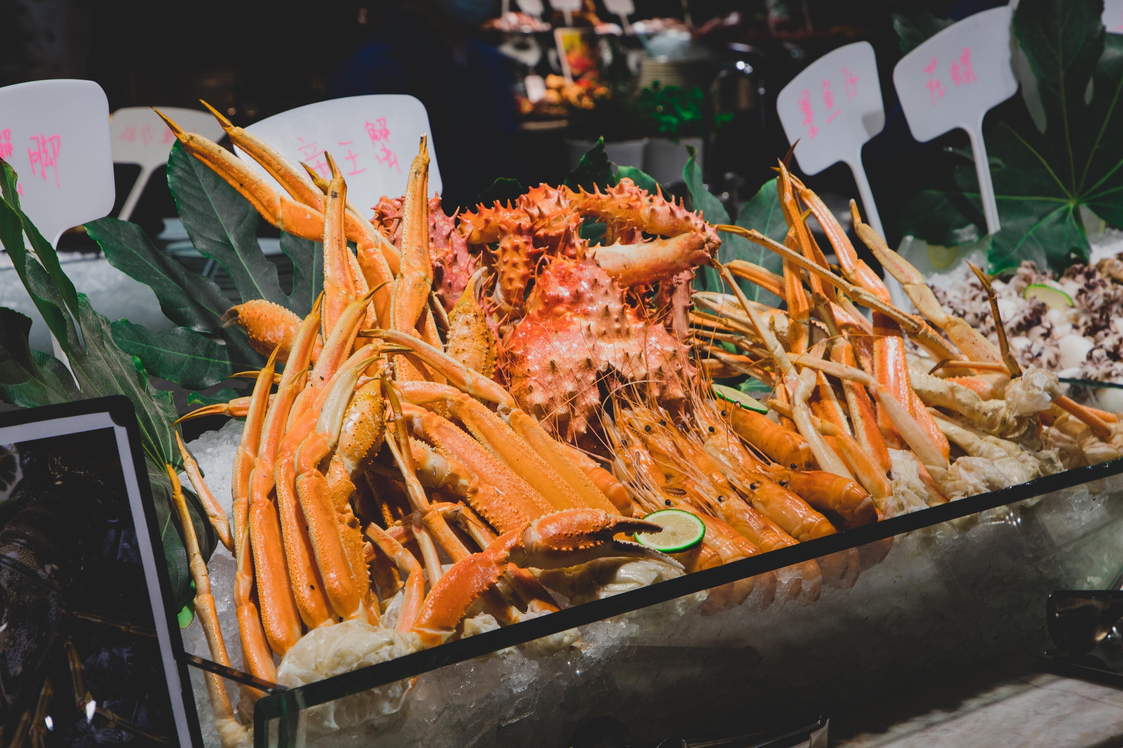 A seafood display with various types of crabs and lobsters on ice.