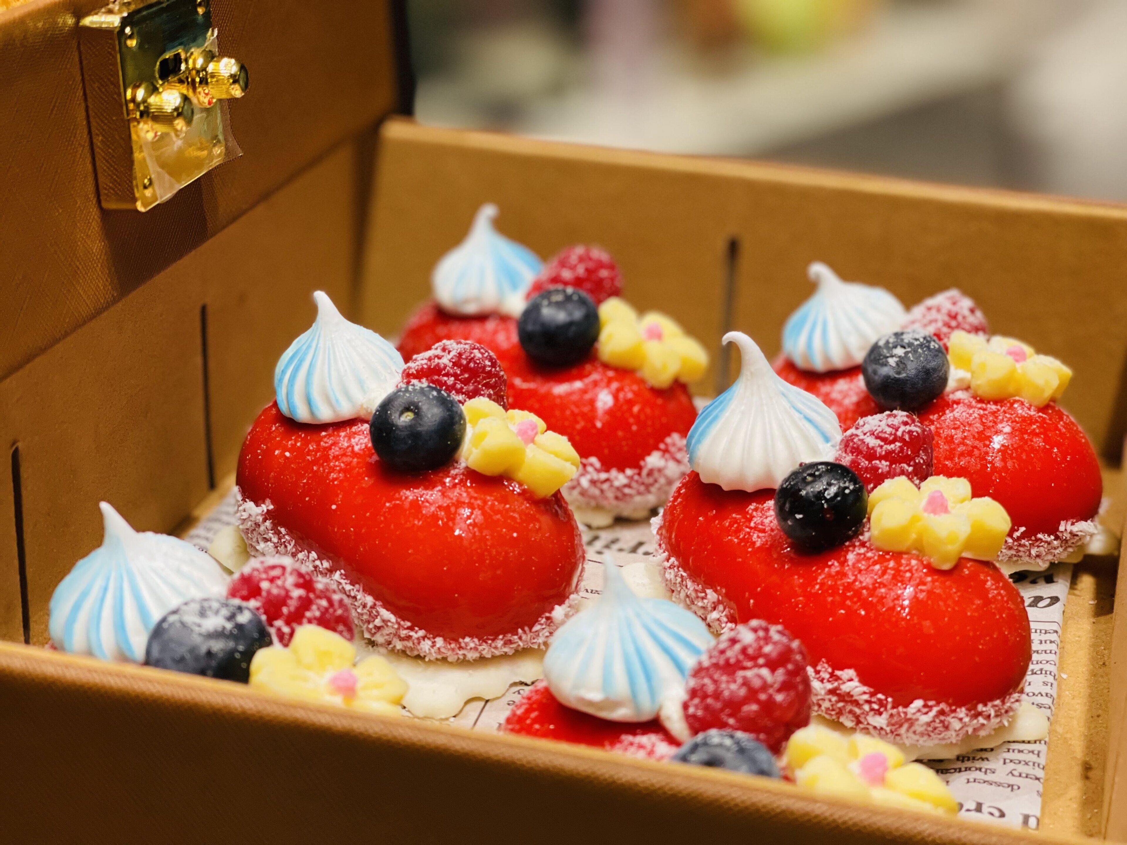 A box of assorted pastries with various toppings.