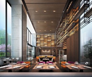 A modern restaurant with high ceilings, large windows, and a central dining area with tables and chairs. - Crowne Plaza Kunshan by IHG (Suzhou)