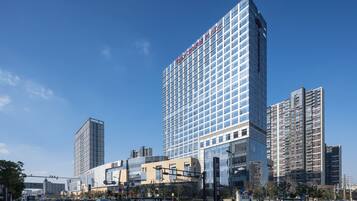A high-rise hotel with a modern glass facade and a prominent sign at the top.