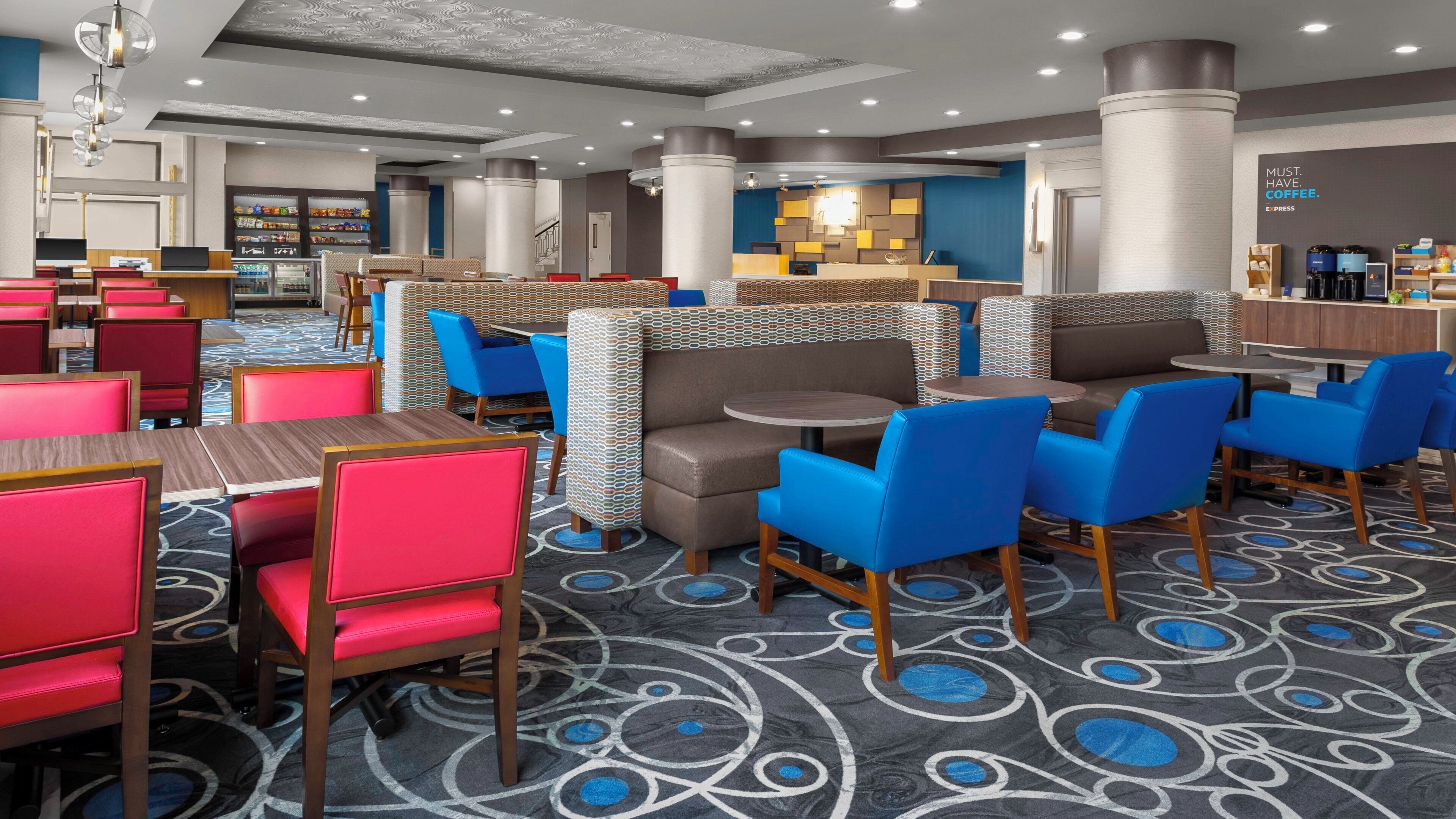 En hotellobby med sittgrupper, en receptionsdisk och en kaffebar.