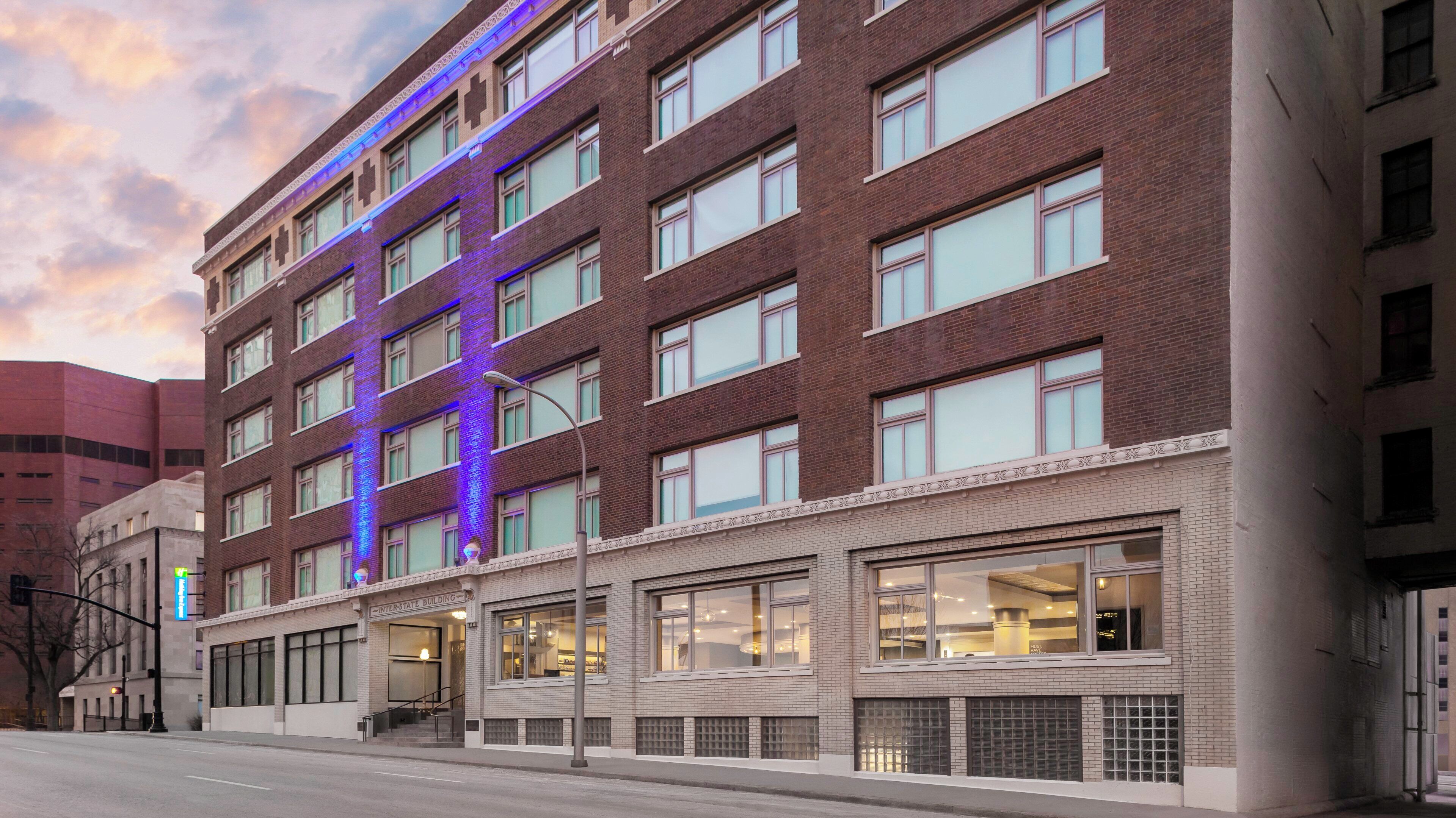 Un hotel de varios pisos con fachada de ladrillo, ventanas amplias y un letrero que indica que es un edificio de carretera.