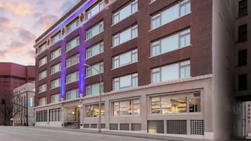 Un hotel de varios pisos con fachada de ladrillo, ventanas amplias y un letrero que indica que es un edificio de carretera.