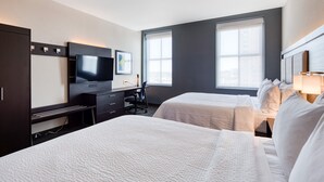 A hotel room with two beds, a desk with a chair, a TV, and large windows. - Holiday Inn Express Kansas City Downtown by IHG (Kansas City)