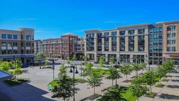 A modern urban plaza with a central roundabout, surrounded by multi-story buildings with commercial establishments.
