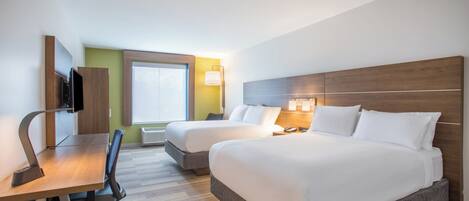 Habitación de hotel con dos camas, un escritorio, una silla, un televisor y una ventana.