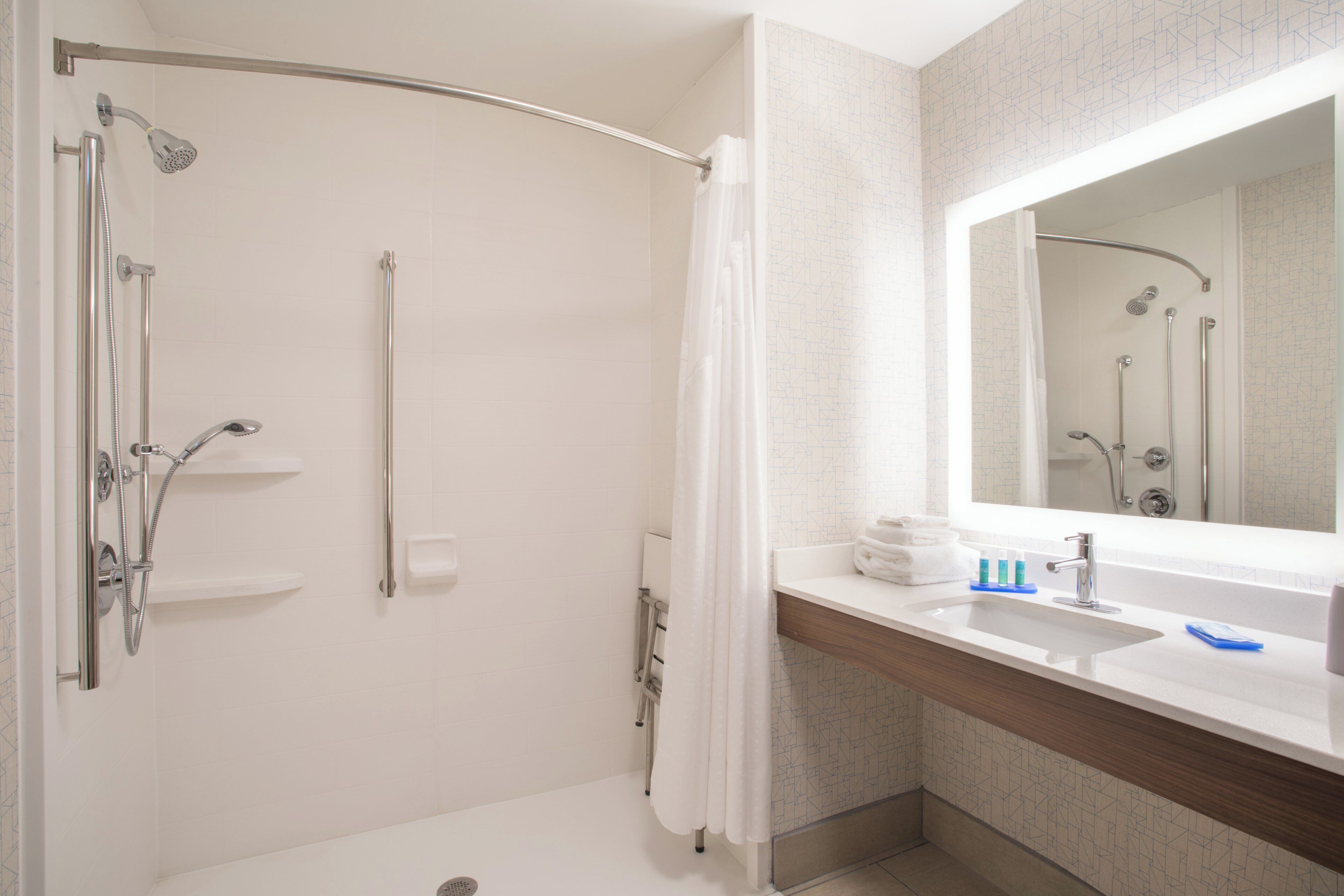 Un baño con ducha, lavabo y espejo.
