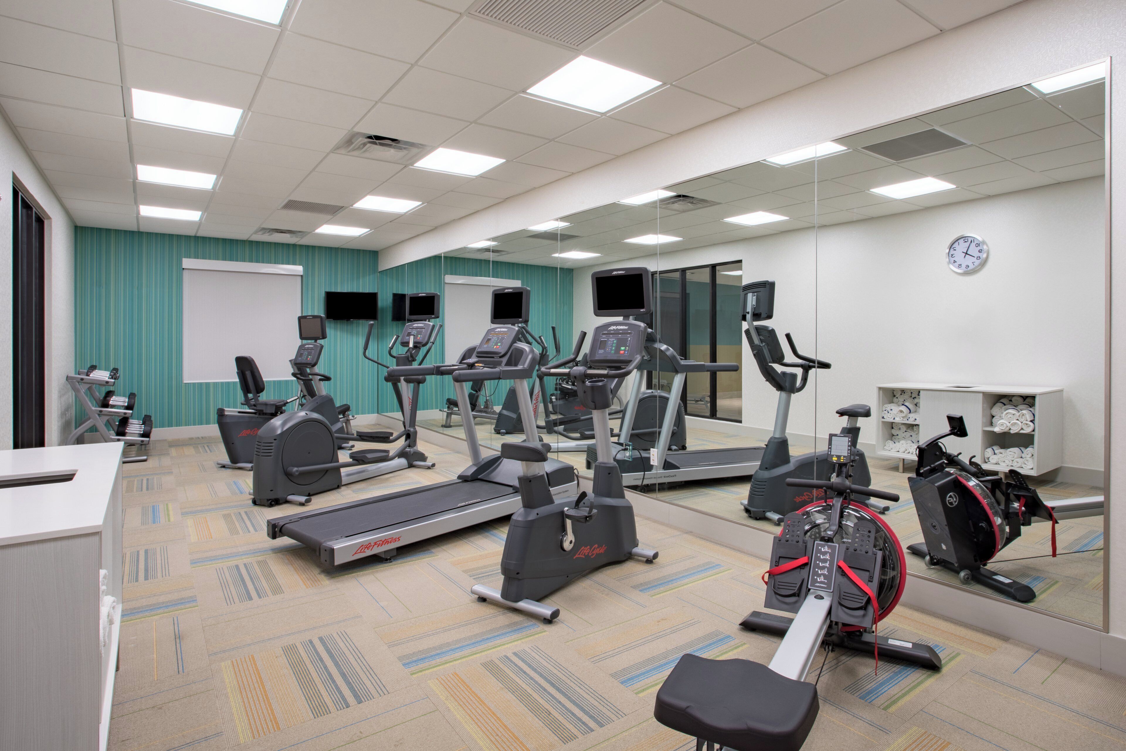 A fitness center with treadmills, elliptical machines, and stationary bikes.