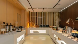 Une cuisine moderne dotée d’un îlot central, d’appareils électroménagers en acier inoxydable et de diverses denrées alimentaires exposées sur des étagères.