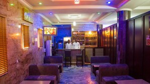 Zona de bar con asientos y una pantalla de televisión.