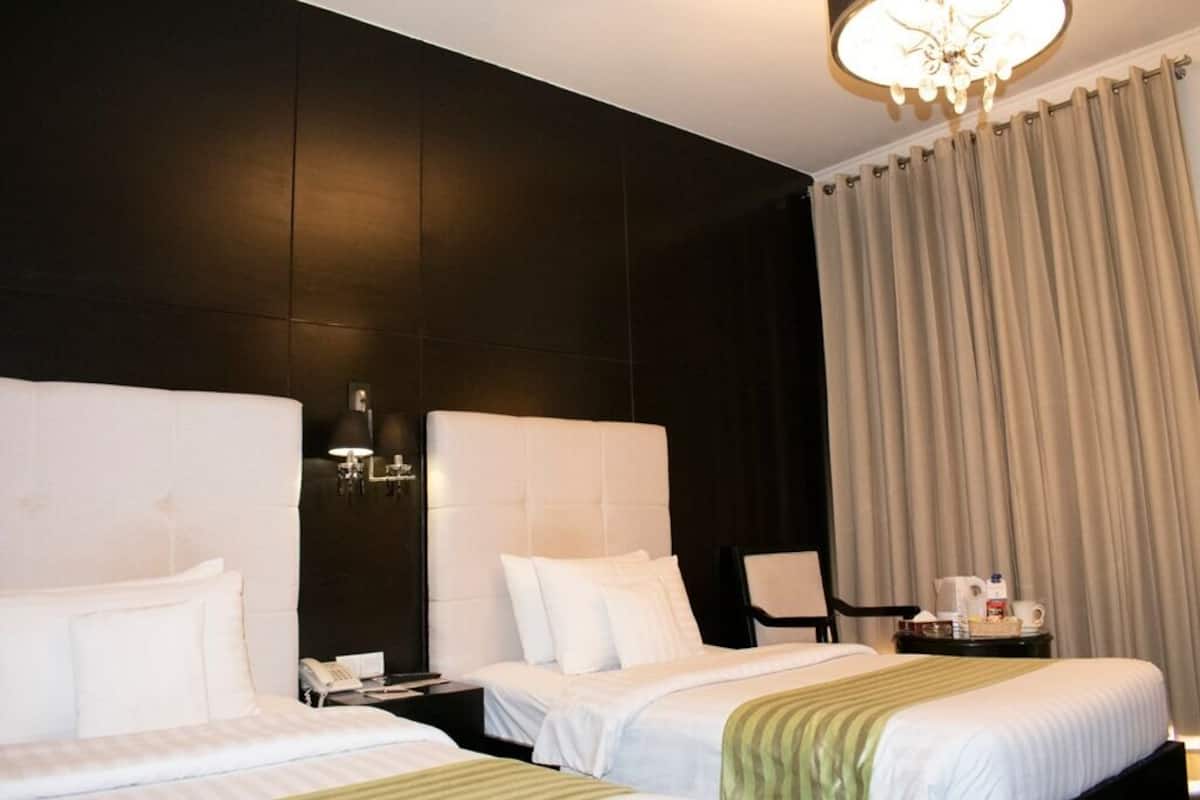 Deluxe eenpersoonskamer, uitzicht op stad | Een minibar, een kluis op de kamer, een bureau, verduisterende gordijnen