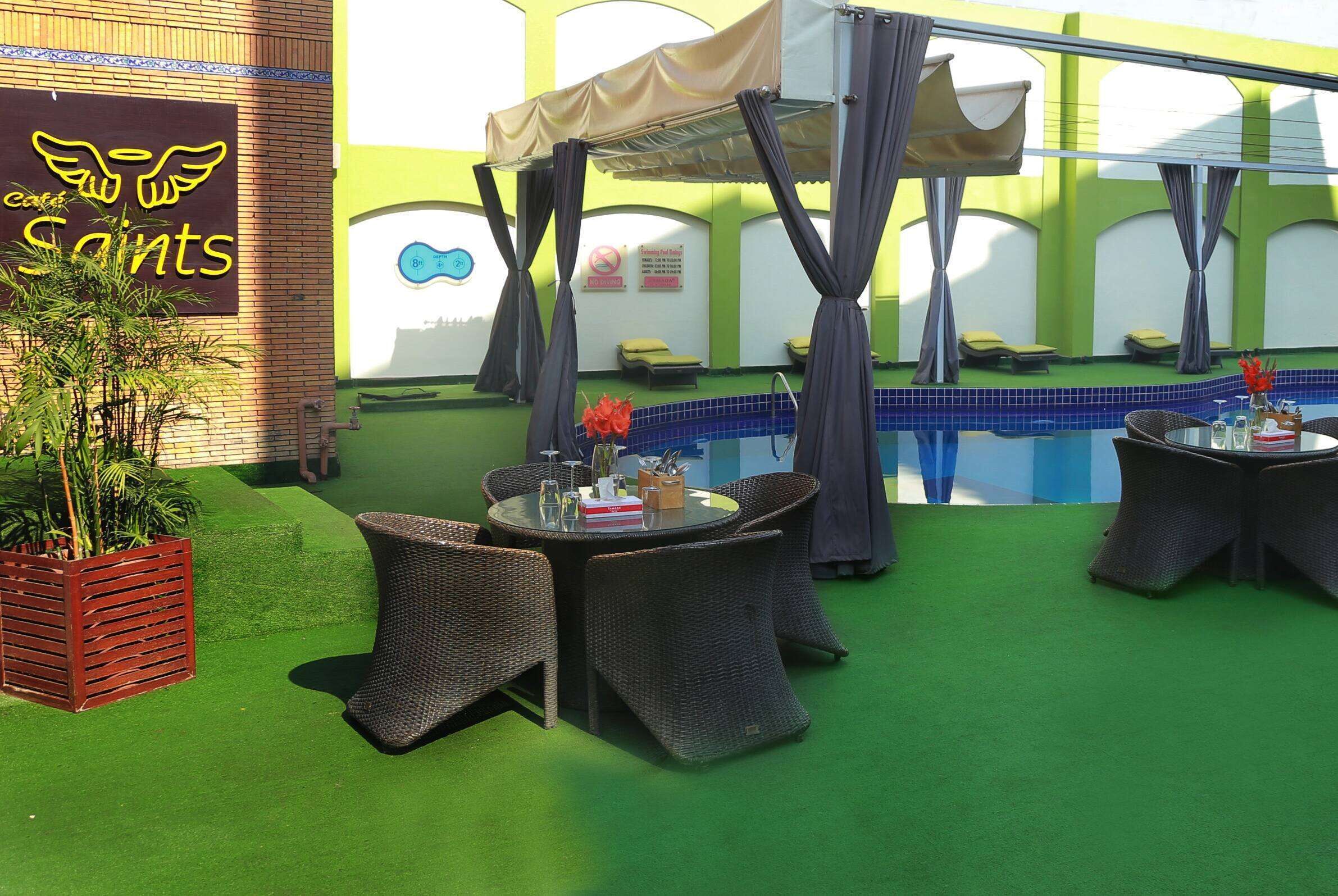 An outdoor pool area with wicker furniture and a tent.
