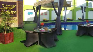 An outdoor pool area with wicker furniture and a tent.