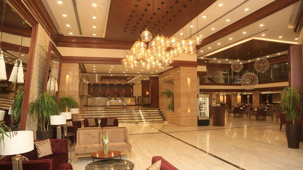 A spacious lobby with a grand chandelier, plush seating, and a reception desk. - Ramada by Wyndham Multan (Multan)