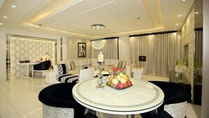 A modern living room with a round glass table, a sofa set, and a chandelier. - Ramada by Wyndham Multan (Multan)