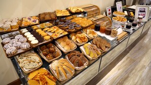 A buffet with various baked goods, including pastries, breads, and rolls. - Ramada by Wyndham Multan (Multan)