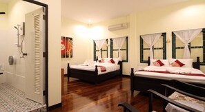 Ein Hotelzimmer mit zwei Betten, einer Dusche und einem Badezimmer.