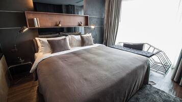 A modern bedroom with a large bed, bedside lamps, a wooden shelf, and a view of the outdoors.