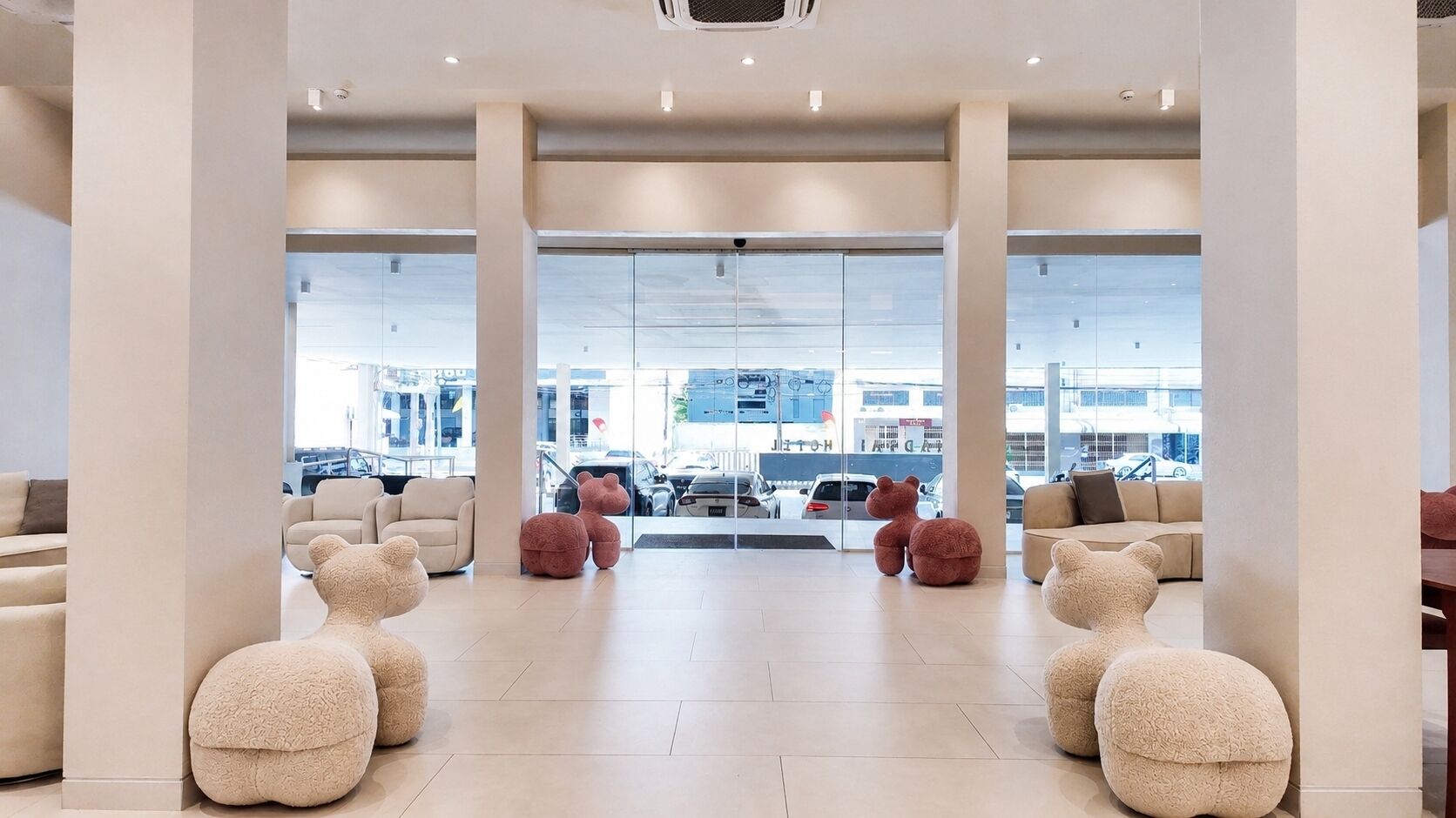 A spacious lobby with large windows, multiple seating areas, and a view of the street outside.