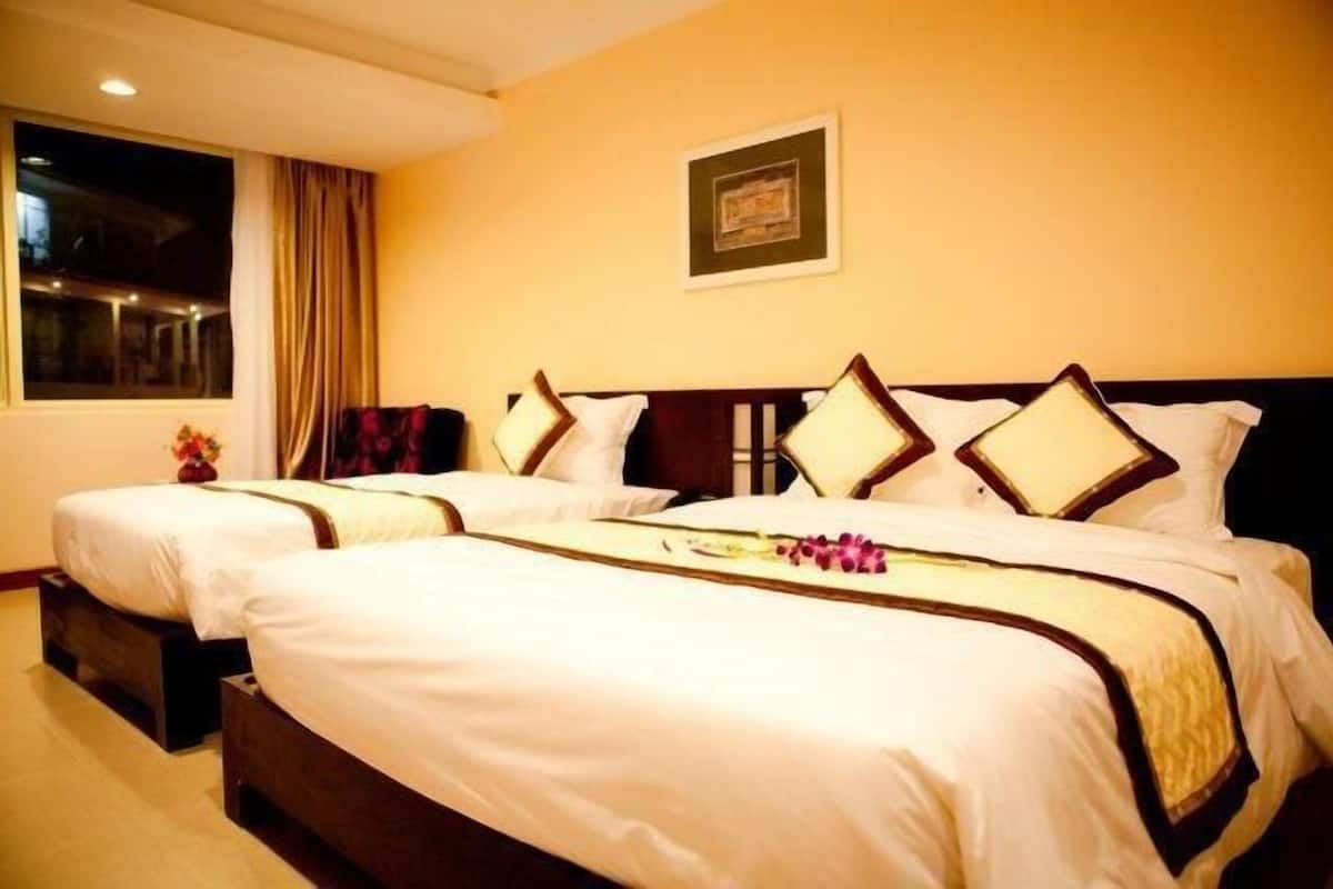 A hotel room with two beds, a large window, and a framed picture on the wall.