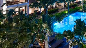 A modern hotel with a swimming pool surrounded by palm trees and lounge areas. - Senvila Boutique Resort & Spa (Da Nang)